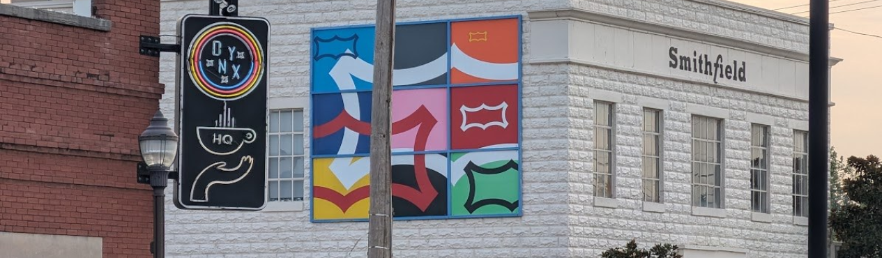 A wide view of a Northwest Arkansas building with colorful local iconography